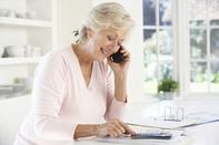 A woman is talking on the phone and writing.