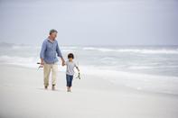 A man and boy walking on the beach