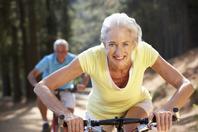 A woman riding on the back of a bicycle.